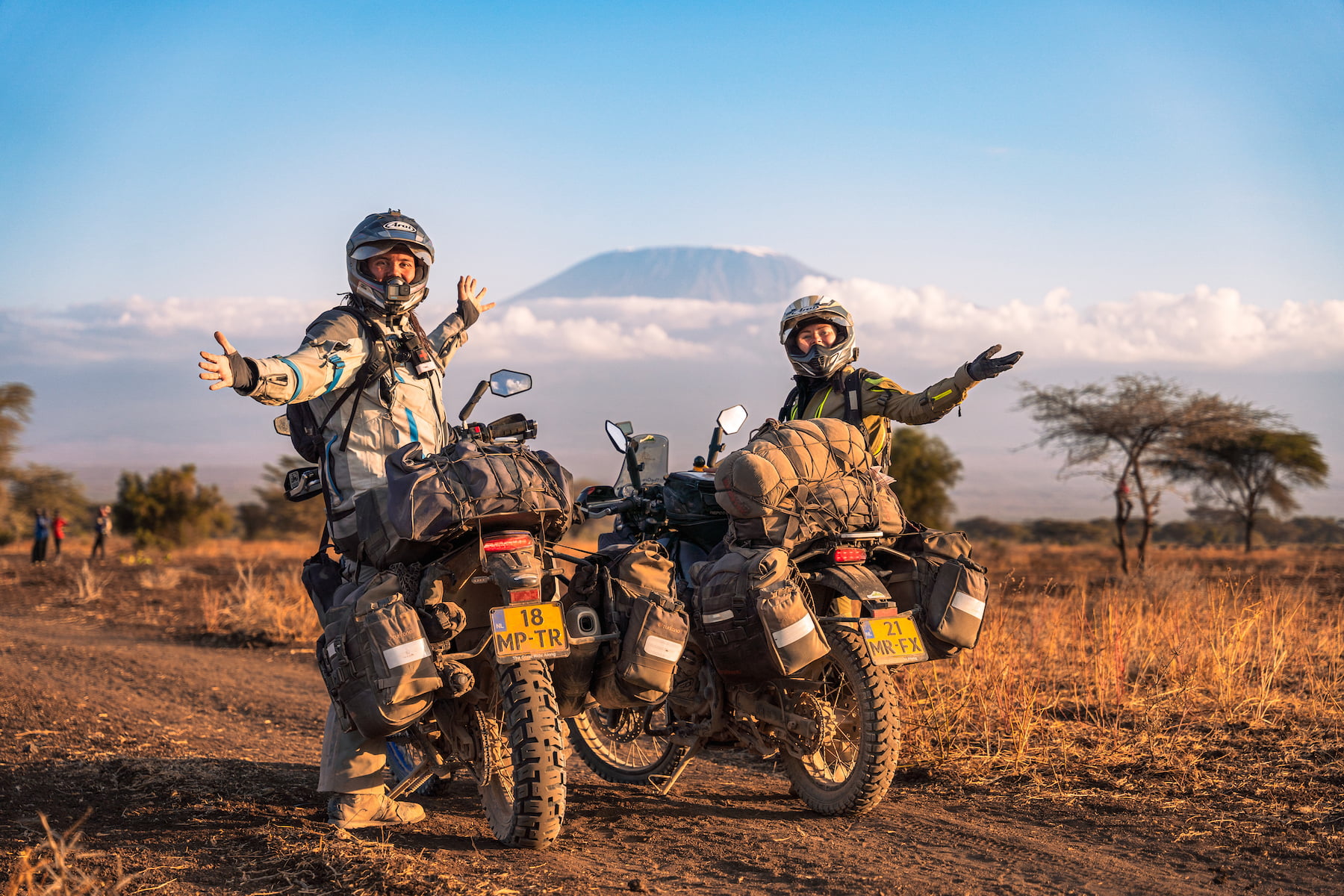Nadia pop en mitchel de jager poserend op hun motoren in kenia voor de klilimanjaro